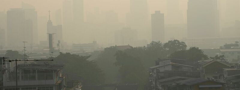 Pendler tragen Gesichtsmasken, um sich vor der Luftverschmutzung zu schützen. - Foto: Sakchai Lalit/AP/dpa