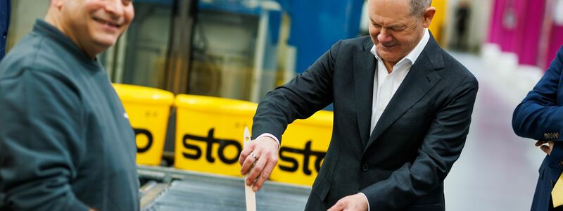 Kanzler Scholz macht beim Baustoffhersteller Sto eine Farbenprobe. - Foto: Philipp von Ditfurth/dpa