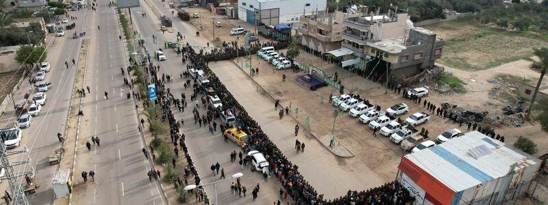 Die Übergabe der Geiseln an das Rote Kreuz im Gazastreifen überwachten zahlreiche vermummte Hamas-Kämpfer. - Foto: Mohammad Abu Samra/AP/dpa