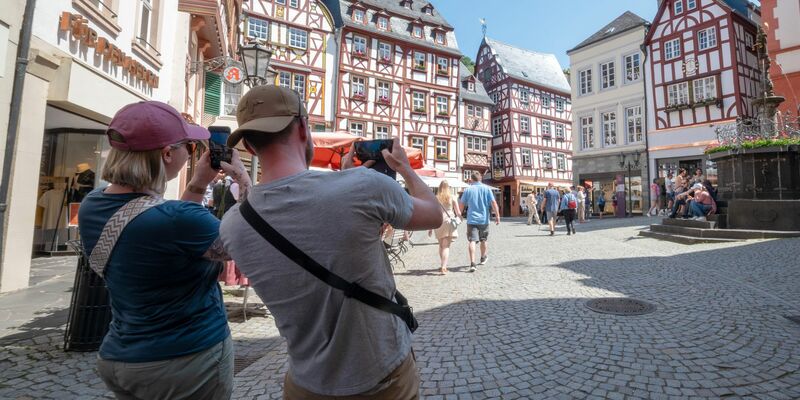 Touristen im Fachwerk-Städtchen Bernkastel-Kues. Die Lust aufs Reisen ist ungebrochen. - Foto: Harald Tittel/dpa