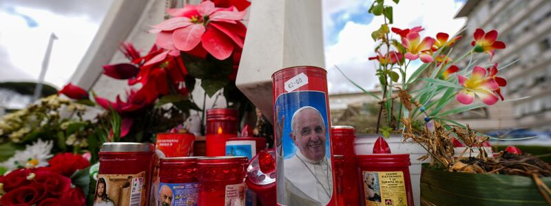 Vor dem Gemelli-Krankenhaus im Rom sind für den erkrankten Papst Franziskus Kerzen aufgestellt. - Foto: Andrew Medichini/AP/dpa