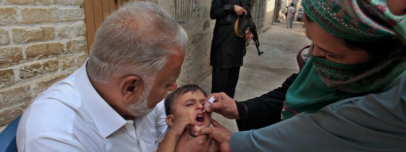 Impf-Teams in Pakistan werden von bewaffneten Männern bewacht, weil sie oft Ziel von Anschlägen sind. (Archivbild) - Foto: Mohammad Sajjad/AP/dpa