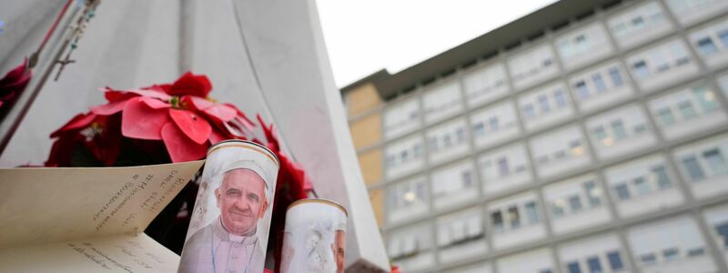 Vor dem Gemelli-Krankenhaus sind Kerzen für den Papst aufgestellt. - Foto: Gregorio Borgia/AP/dpa