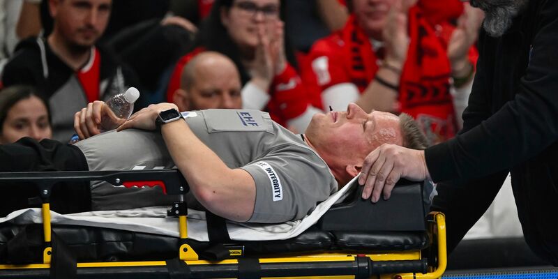 Madsen wird nach seinem Zusammenbruch aus der Halle gebracht.  - Foto: Tamas Vasvari/MTI/AP/dpa