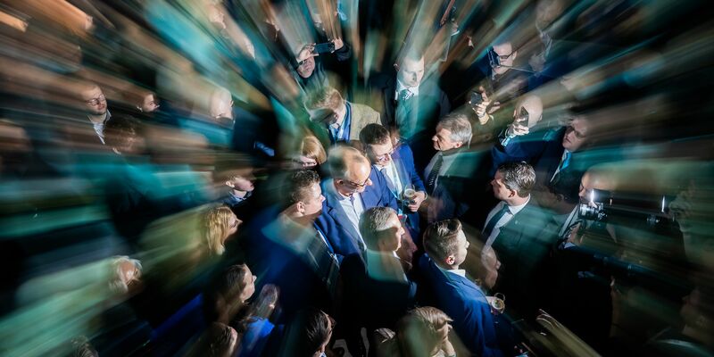 Der Kanzlerkandidat der Union, Friedrich Merz, steht am Wahlabend zwischen Parteifreunden in der CDU-Parteizentrale. - Foto: Christoph Soeder/dpa