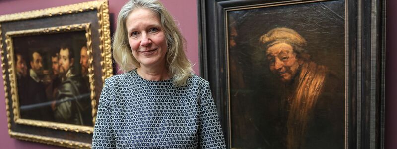 Anja Sevcik steht zwischen einem Selbstbildnis von Peter Paul Rubens unter Freunden (links) und einem Selbstbildnis von Rembrandt (rechts).  - Foto: Oliver Berg/dpa