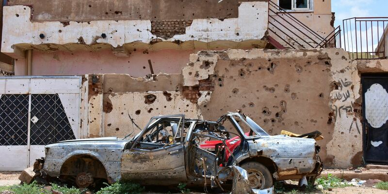 Ein zerstörtes Auto steht im sudanesischen Omdurman vor einem Haus voller Einschüsse. (Archivbild) - Foto: Mudathir Hameed/dpa