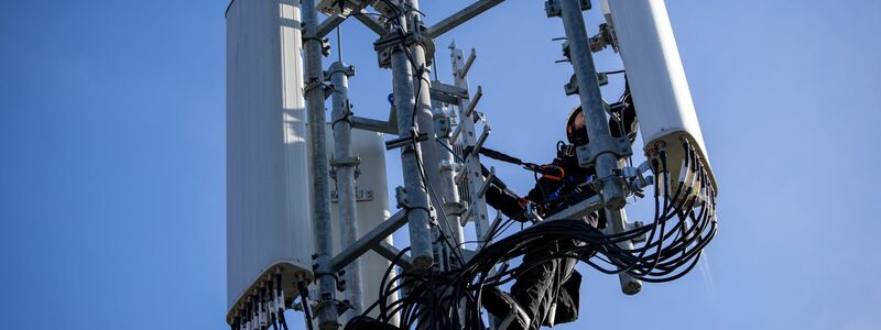 Einer von Zehntausenden Mobilfunk-Masten in Deutschland - hier einer, an dem gerade ein Techniker arbeitet. - Foto: Daniel Karmann/dpa