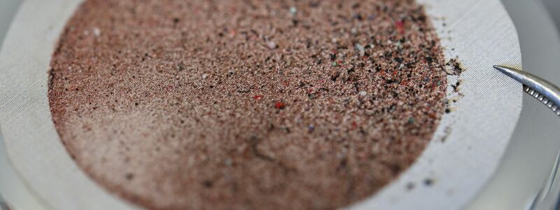 Mikroplastikpartikel haben sich nach Filtration auf einer Edelstahlmembran abgesetzt. (Symbolbild) - Foto: Arne Dedert/dpa