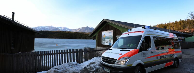 Eine Frau steht am Ufer des zugefrorenen Eibsees, nahe der Stelle an der am Nachmittag mehrere Menschen im Eis eingebrochen waren. - Foto: Karl-Josef Hildenbrand/dpa