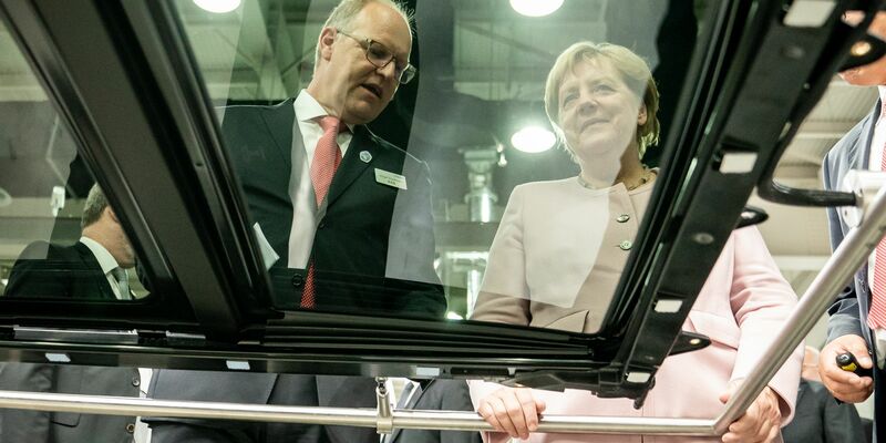 Der scheidende Webasto-Chef Holger Engelmann in besseren Tagen im Jahr 2019. Hier demonstriert der Manager der früheren Bundeskanzlerin Angela Merkel in einem Werk im chinesischen Wuhan die Fertigung von Schiebedächern. - Foto: Michael Kappeler/dpa
