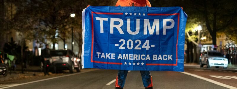 Trump-Unterstützer im Spider-Man-Kostüm mit einem Trump-Transparent am Tag der US-Präsidentschaftswahl 2024 in Washington. - Foto: Probal Rashid/ZUMA Press Wire/dpa