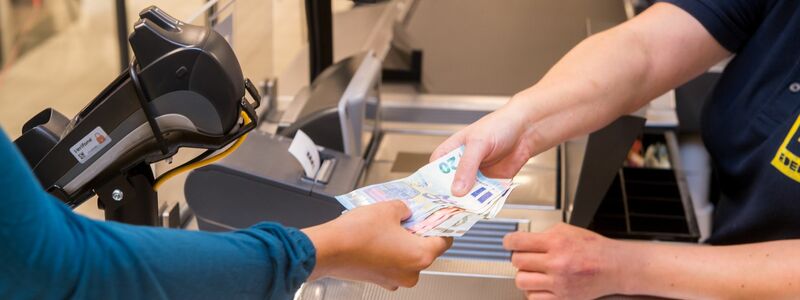 In einem Supermarkt hebt eine Kundin beim Bezahlen auch gleich Bargeld ab. - Foto: Benjamin Nolte/dpa