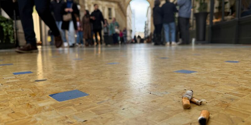 Eine Touristin mit Zigarette in der Hand vor dem Dom in Mailand. - Foto: Christoph Sator/dpa