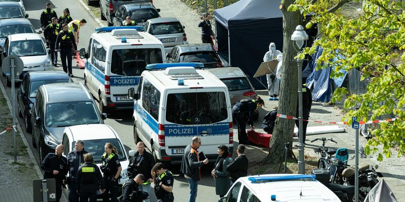 Polizisten und Beamte der Spurensicherung in weißen Schutzanzügen stehen an dem Ort, wo ein toter Mann gefunden wurde.  - Foto: Hannes P. Albert/dpa