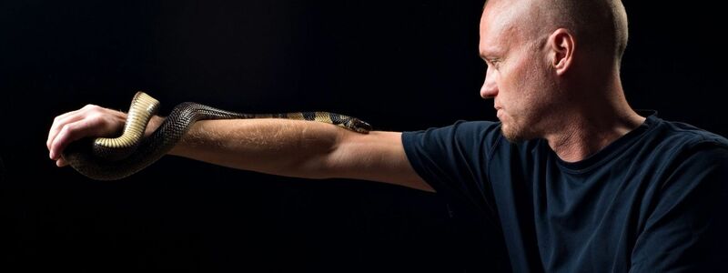 Der von Schlangen begeisterte US-Amerikaner Tim Friede hat sich selbst immer größere Dosierungen von Schlangengiften verabreicht und kann nun einfach so eine Wasserkobra auf dem Arm tragen.  - Foto: ---/Centivax/dpa