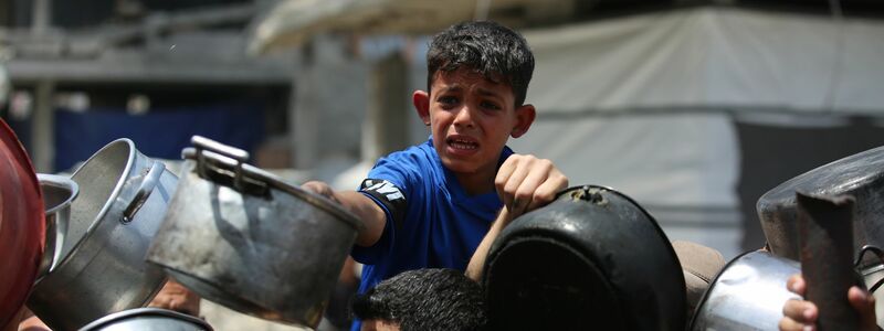Kinder im Gazastreifen warten auf warmes Essen.  - Foto: Omar Ashtawy/APA Images via ZUMA Press Wire/dpa
