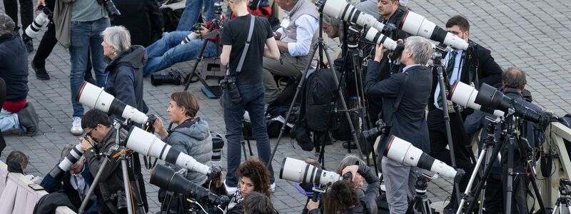 Auf dem Petersplatz warten Journalistinnen und Journalisten gespannt auf das erste Rauchzeichen aus der Sixtinischen Kapelle. - Foto: Marijan Murat/dpa