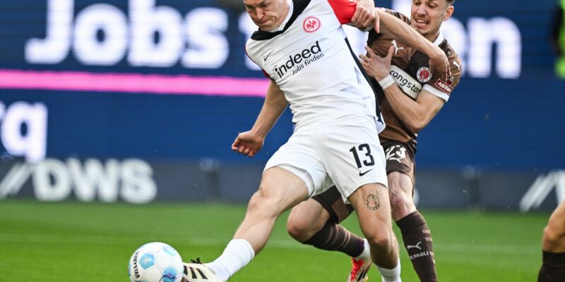Eintracht Frankfurt um Arthur Theate (l) und der FC St. Pauli mit Manolis Saliakas lieferten sich eine wilde Anfangsphase. - Foto: Arne Dedert/dpa