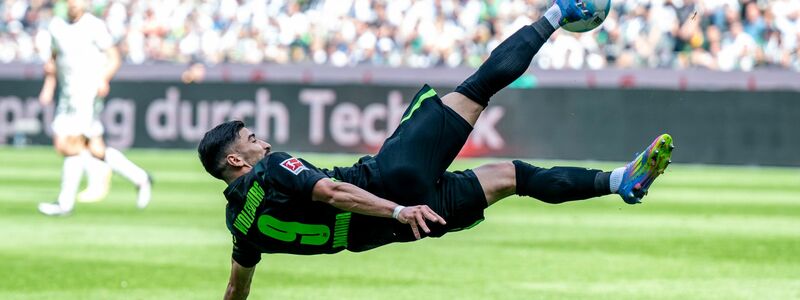 Grün gegen Weiß: Wolfsburgs Saël Kumbedi (r) im Zweikampf mit dem Gladbacher Luca Netz. - Foto: David Inderlied/dpa