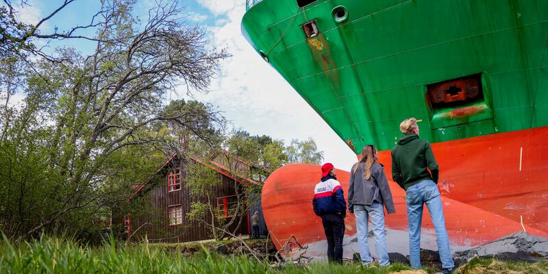 Das war knapp: Ein Containerschiff ist in einem norwegischen Fjord kurz vor einem Haus am Wasser zum Stehen gekommen. - Foto: Jan Langhaug/NTB/dpa