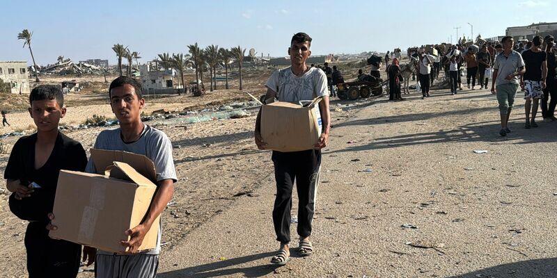Palästinenser mit Hilfsgütern. - Foto: Ahmed Ibrahim/APA Images via ZUMA Press Wire/dpa