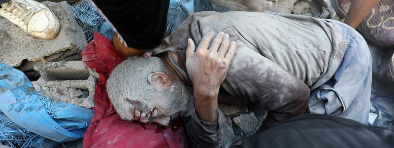 Palästinenser nach dem Angriff auf Gebäude im Flüchtlingsviertel Al-Bureidsch.  - Foto: Moiz Salhi/APA Images via ZUMA Press Wire/dpa