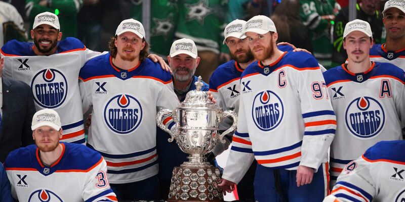 Leon Draisaitl posiert hinter Kapitän Connor McDavid mit dem Pokal für den Sieger der Western Conference. - Foto: Julio Cortez/AP/dpa