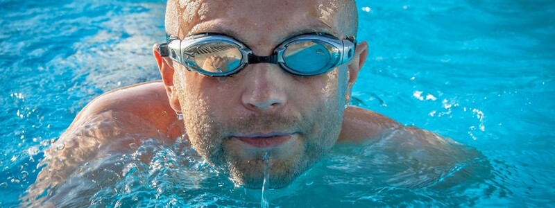 Mann schwimmt mit einer Schwimmbrille in einem Pool.  - Foto: Pixabay@jarmoluk