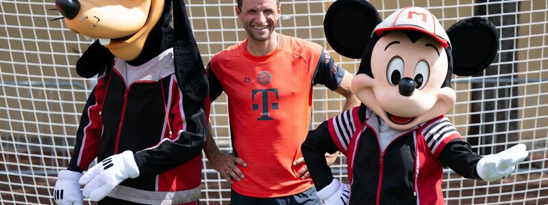 Thomas Müller mit Goofy und Micky Maus. - Foto: Sven Hoppe/dpa