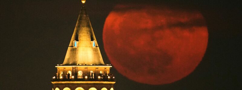 Der Erdbeermond geht hinter dem Galata-Turm in Istanbul auf. - Foto: Emrah Gurel/AP/dpa