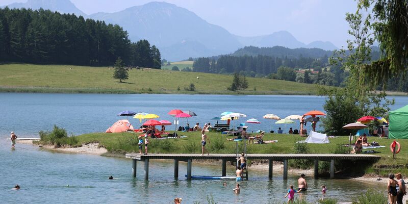 Ausflügler suchen Abkühlung am Illasbergsee im Allgäu. - Foto: Karl-Josef Hildenbrand/dpa