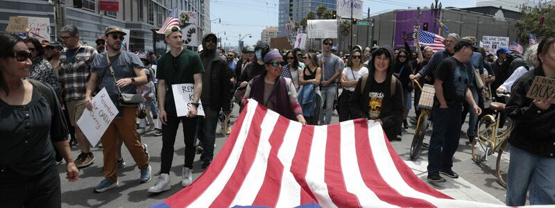 Demonstranten in San Francisco marschierten mit einer großen US-Flagge. - Foto: Yalonda M. James/San Francisco Chronicle/AP/dpa