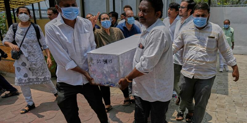 Arbeiter sind an der Absturzstelle im Einsatz. - Foto: Rafiq Maqbool/AP/dpa