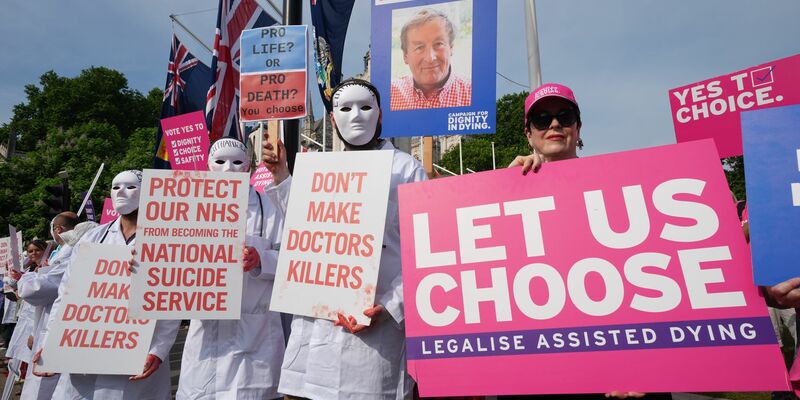Befürworter und Gegner einer Regelung, die Sterbehilfe ermöglicht, vor dem Parlament in London. - Foto: Lucy North/PA Wire/dpa