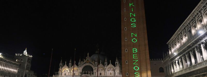 Auf dem Markusturm steht groß: «No Kings no Bezos» («Keine Könige, kein Bezos»). - Foto: Antonio Calanni/AP/dpa