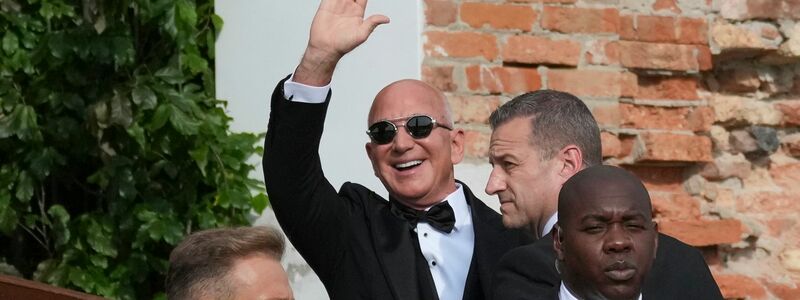 Amazon-Gründer Jeff Bezos winkt Paparazzi zu. - Foto: Antonio Calanni/AP/dpa