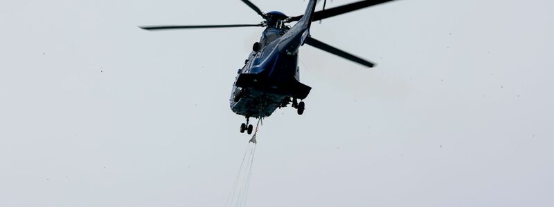 Ein Löschhubschrauber der Bundespolizei fliegt über dem Zeithainer Tagebau und nimmt Wasser auf, um den Waldbrand Gohrischheide zu bekämpfen. - Foto: Daniel Wagner/dpa