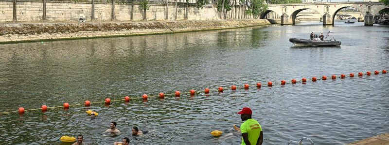Zur Eröffnung der drei neuen Freibäder in der Seine standen die ersten Schwimmerinnen und Schwimmer schon morgens Schlange. - Foto: Julien De Rosa/AFP/dpa