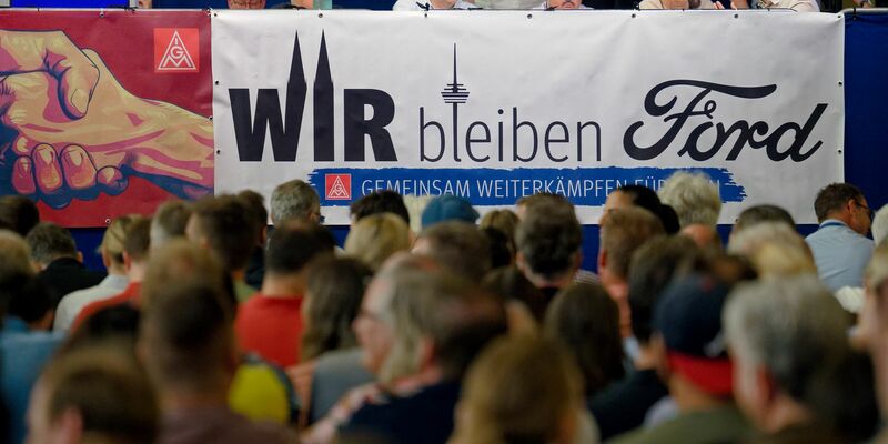 Ford-Logo an einem Werkstor des Autobauers, der in Köln noch große Flächen hat - obwohl er personell schon seit langem schrumpft. - Foto: Henning Kaiser/dpa