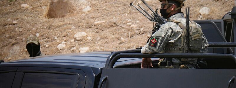 Sicherheitskräfte der kurdischen Regionalverwaltung sichern den Ort, wo die Waffenniederlegung stattfand. - Foto: Hadi Mizban/AP/dpa
