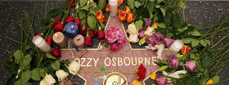 Blumen liegen um den Stern für Ozzy Osbourne auf dem Hollywood Walk of Fame. - Foto: Damian Dovarganes/AP/dpa