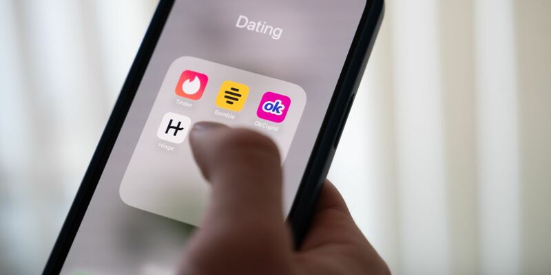 Eine Frau hält ein Smartphone, auf dem Dating-Apps angezeigt werden. (Symbolbild) - Foto: Alicia Windzio/dpa