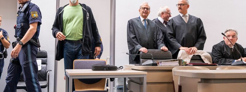 Angeklagte nehmen vor der Urteilsverkündung auf der Anklagebank Platz. - Foto: Peter Kneffel/dpa