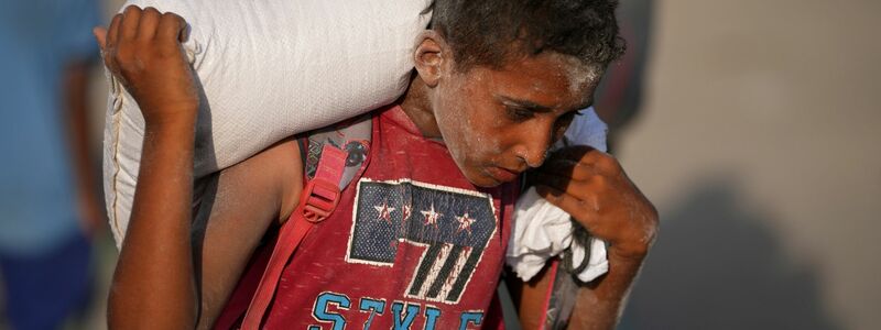 Ein palästinensischer Junge trägt einen Sack Mehl. (Archivbild) - Foto: Jehad Alshrafi/AP/dpa