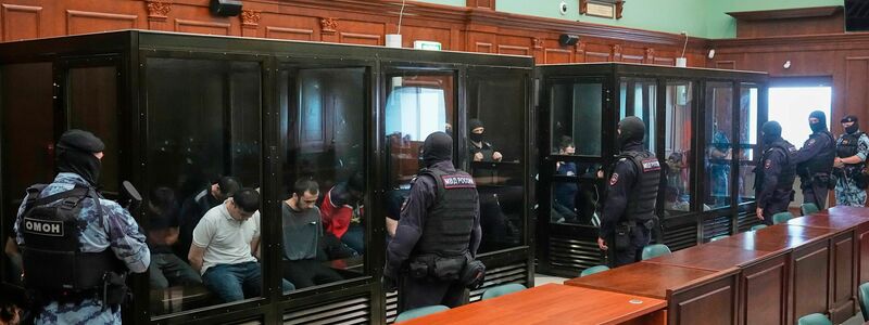 Die 19 Angeklagten saßen schwer bewacht in gläsernen Käfigen.  - Foto: Pavel Bednyakov/AP/dpa