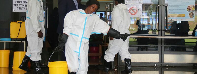 Eine Mitarbeiterin trägt Desinfektionsmittel aus einem Cholera-Behandlungszentrum (Archivbild) - Foto: --/AP/dpa