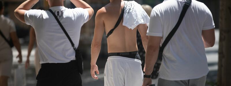 Junge Männer gehen mit nacktem Oberkörper auf Mallorca spazieren. (Archivbild) - Foto: Clara Margais/dpa