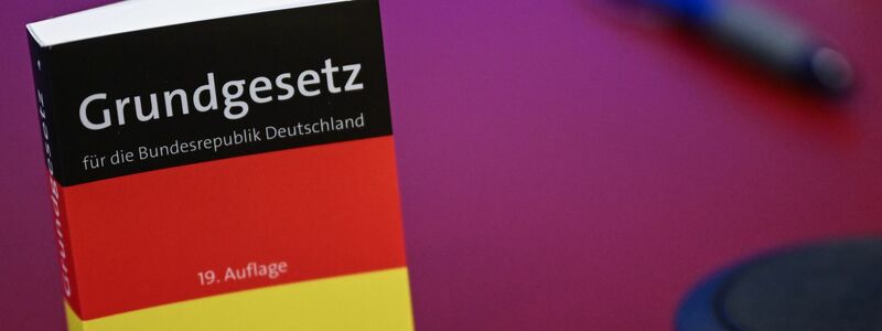 Das Grundgesetz in Miniatur-Ausgabe steht bei der Pressekonferenz zur AfD auf einem Tisch.  - Foto: Britta Pedersen/dpa
