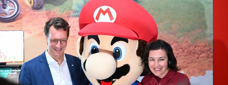Beim Messerundgang über die Gamescom kam der Tross von Politikern auch beim Messestand von Nintendo vorbei, hier stehen NRW-Ministerpräsident Hendrik Wüst (CDU) und Bundesforschungsministerin Dorothee Bär (CSU) neben einer Mario-Plüschfigur. - Foto: Wolf von Dewitz/dpa
